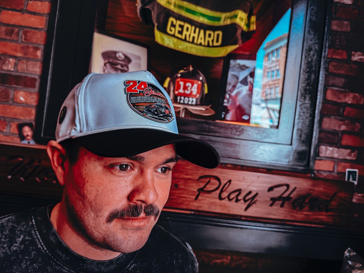 Talladega Collection lifestyle — snapback and cut-off worn at the track